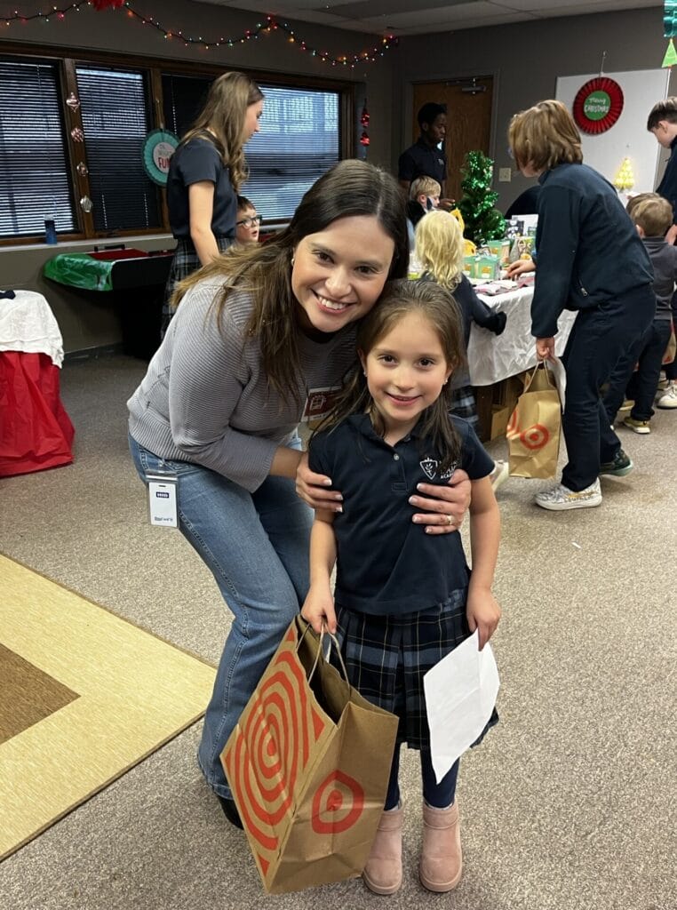 A parent volunteer helps a student shop for Christmas presents at the Christmas Boutique.